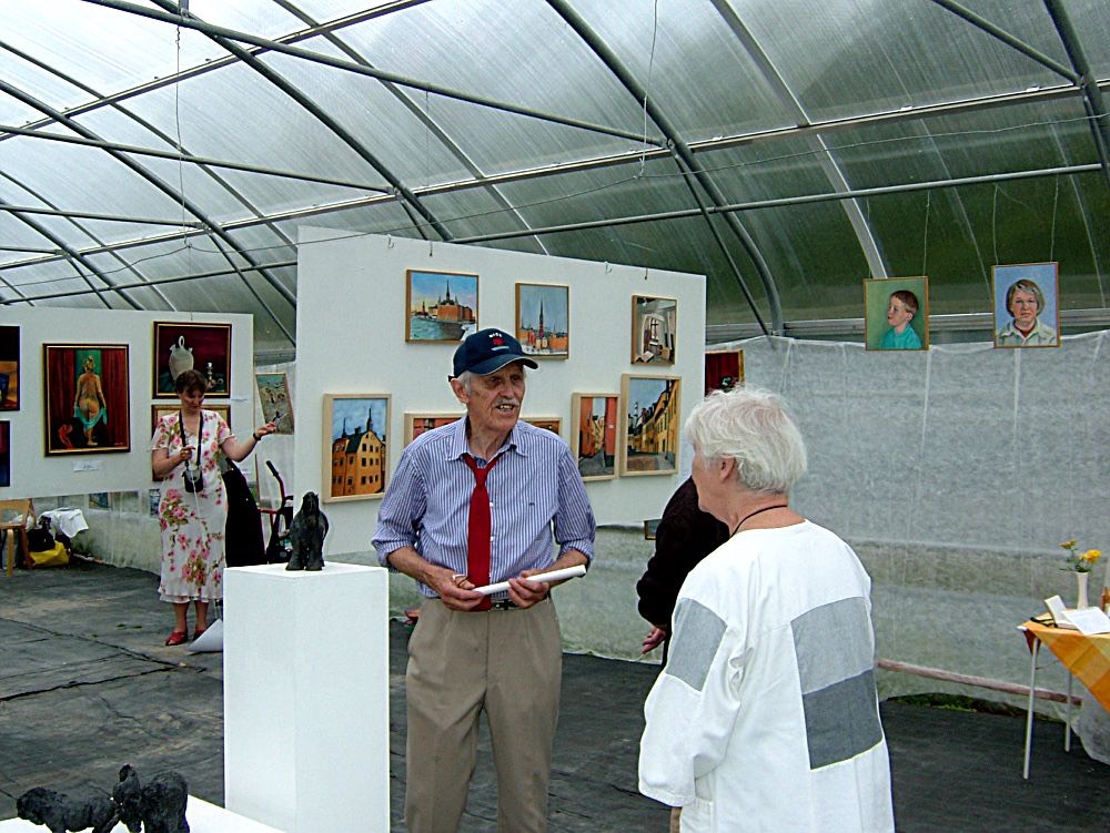 Curator Nils Hinnas i samspråk med besökare på utställningen.