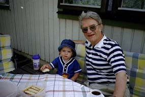 Felix och Morfar sitter och samtalar i trädgården. 1999-07-20