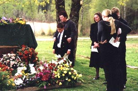 De närvarande går fram och tar avsked vid den öppna graven. Här är det Renate, Lukas, Sara och Linda som tar avsked. 2000-05-03 Foto: Toje Stenbaek