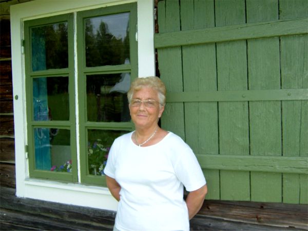 Elsie mår gott i solen vid stugväggen, 9/6 -06
