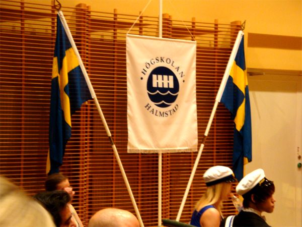 Högskolans standard och svenska flaggan.