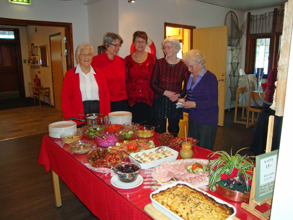 Festkommittén framför det dukade julbordet; 6/12 -12