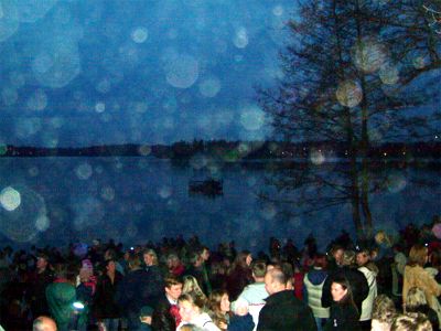 Den traditionsenliga flotten skymtar i mörkret ute på sjön. Därute sitter en familj och äter samtidigt som de tittar på vår brasa och lyssnar till vårens sånger, 30/4 -04
