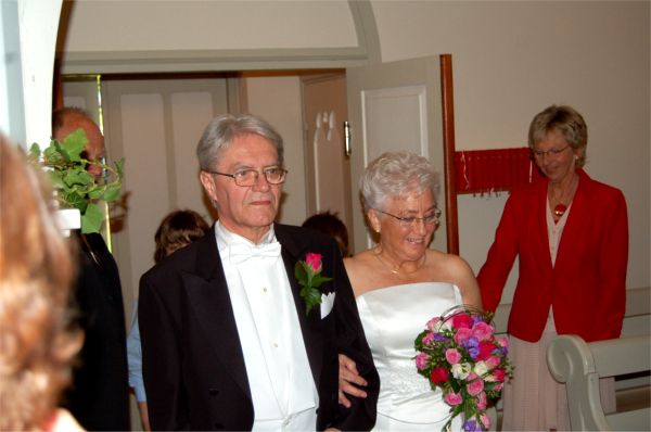 Värdparet släpper in brudparet genom kyrkporten. Vi är nu på väg mot altaret i Ceciliakyrkan där pastorn Peter Bernhardsson från Pingst Jönköping väntade.