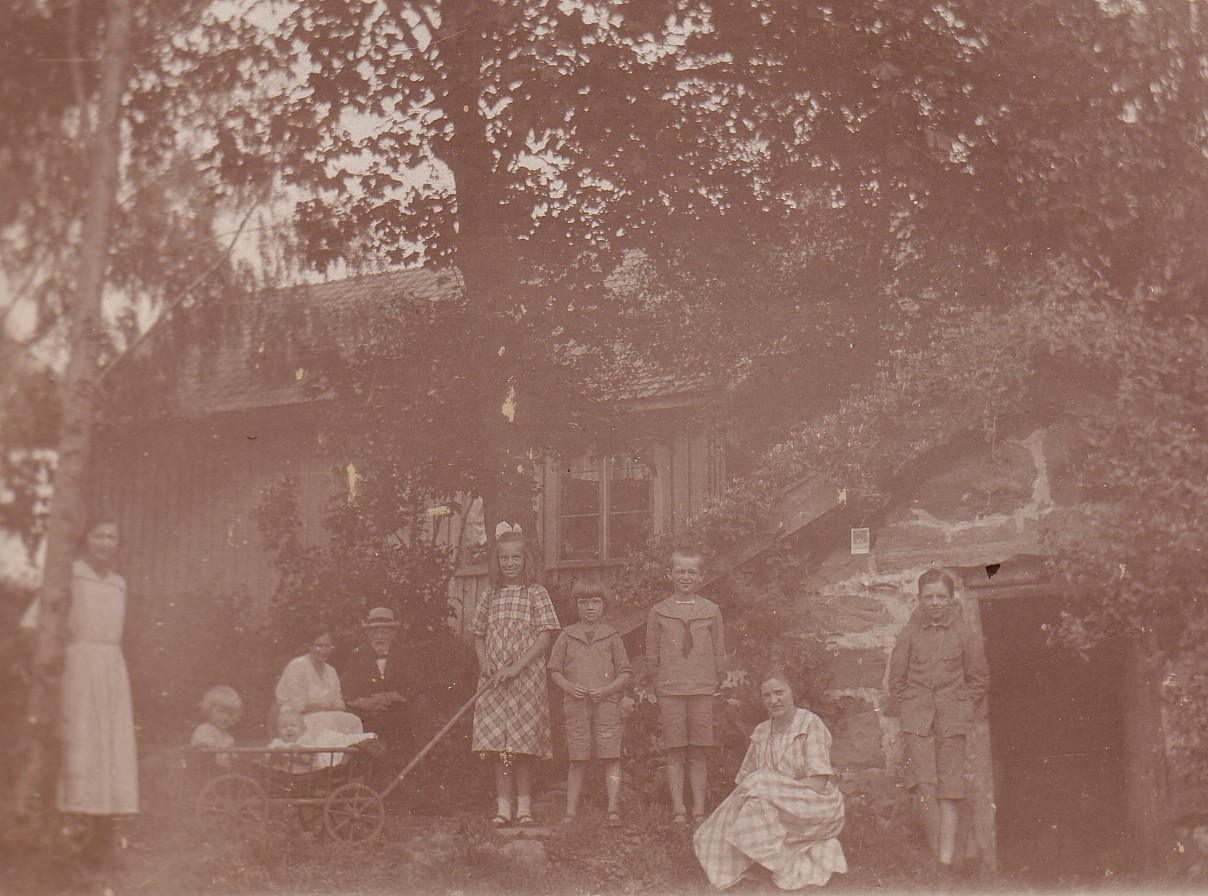 Familjen utanfor jordkallaren bakom skolan 1921